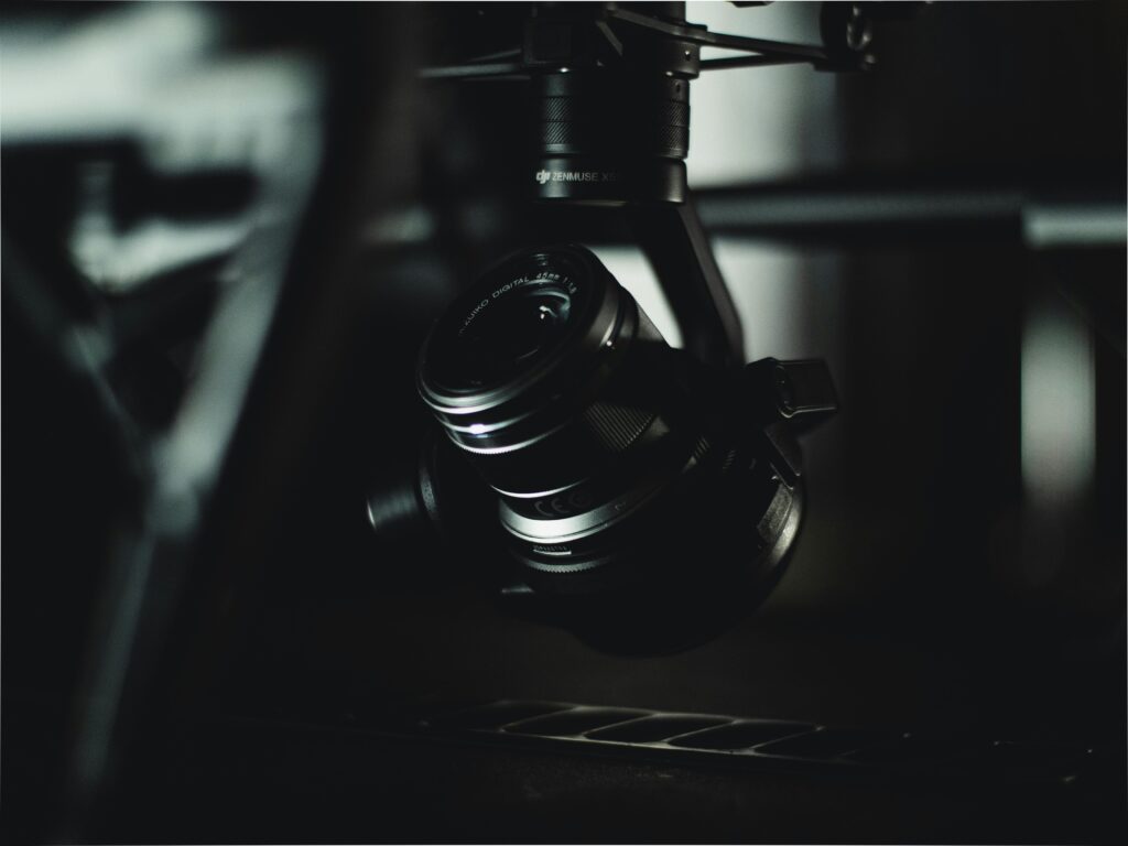 Detailed close-up of a camera lens mounted on a gimbal, in low light.